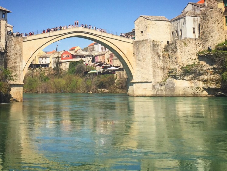 The old bridge is over the incredibly clear waters that reflect the bridge like a mirror in Bosnia and Hertz. Mostar