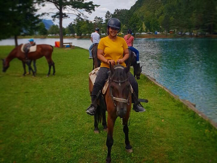 Charlie the brown horse in Bled Slovenia being ridden in a yellow top