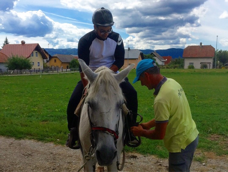 Ifran in a helpment getting ready to ride the horse called Tim around the mountains in Bled Slovenia