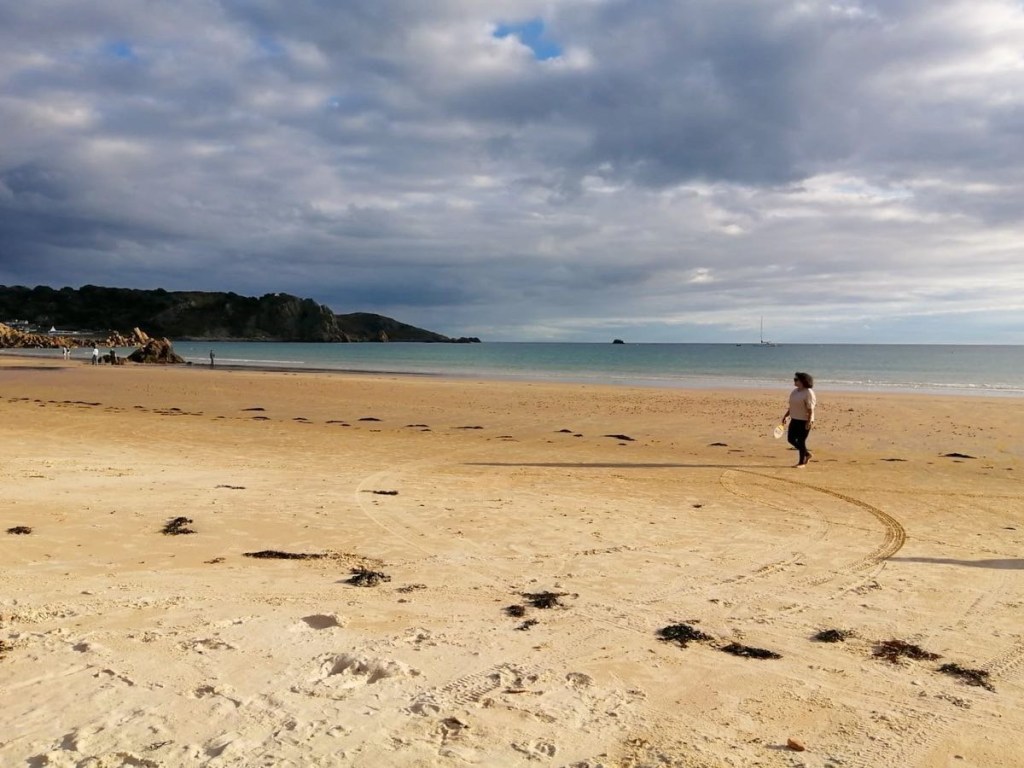 St Brelades Bay in Jersey. Woman playing on the beach 