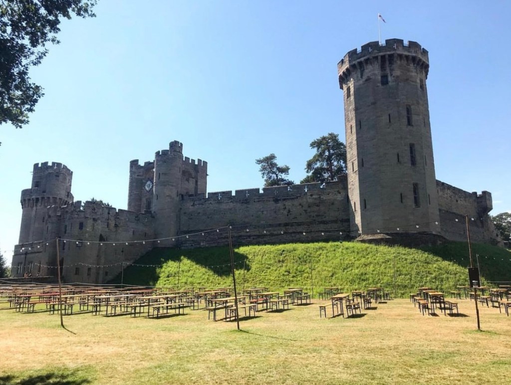 Warwick castle entrance with benches at the front. 
