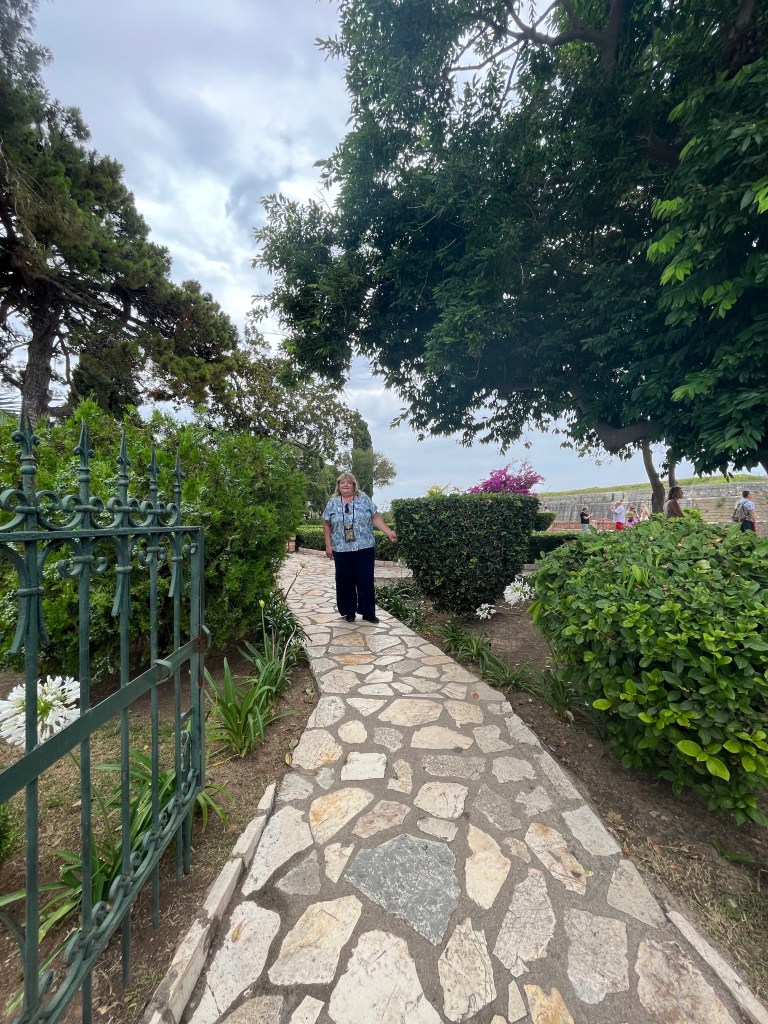 A woman stands on the path in Corfu Public Gardens in Greece 