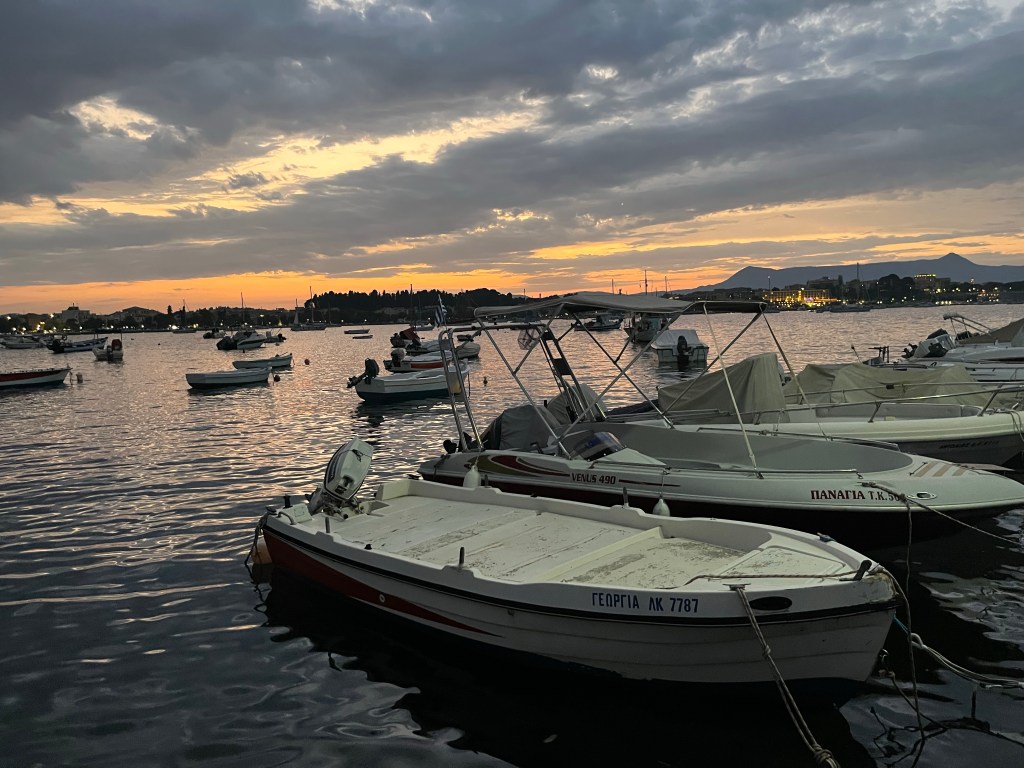 Sunset with boats and cloudy skies in Greece near Mon Repos Palace. 