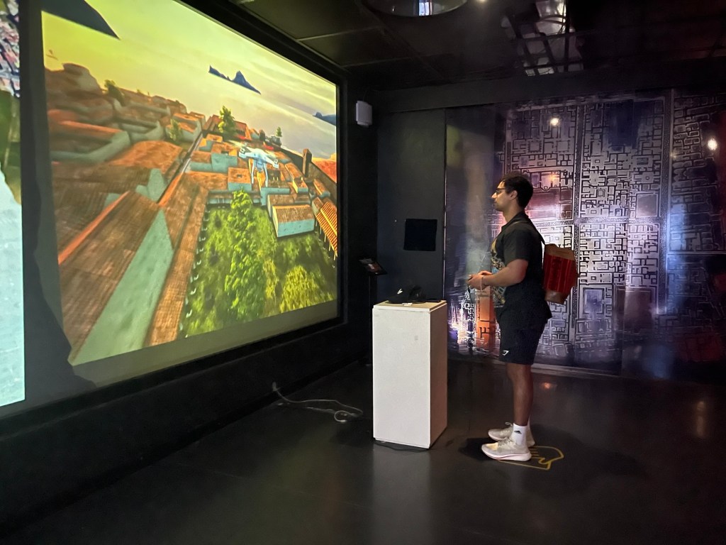 A man plays with a museum game that allows him to fly a drone over Naples. 